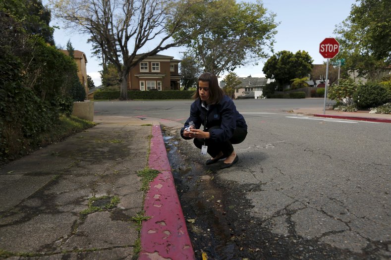 Jolene Bertetto, a water conservation technician with East Bay Municipal Utility District, takes a water sample from a neighborhood in Oakland, California April 8, 2015. Bertetto was conducting investigations into waste water and sources of water leaks as the state's top water regulators released a framework for enforcing California's first statewide mandatory restrictions on urban water use.