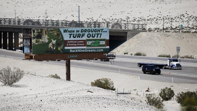 A sign advertising artificial turf is seen in Cathedral City, California, April 13, 2015.