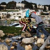 Palestinian children collect water in the Sheikh Jarrah neighbourhood in East Jerusalem