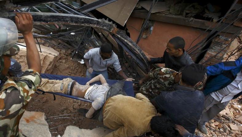 People carry the body of a victim from a damaged house after an earthquake hit, in Kathmandu, Nepal April 25.