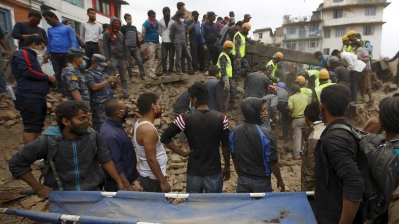 Rescue workers search for bodies as a stretcher is kept ready after an earthquake hit, in Kathmandu, Nepal April 25, 2015.