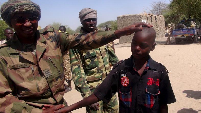 A Chadian soldier embraces a former child soldier of Boko Haram who said he was forced to join the group while studying in Nigeria.