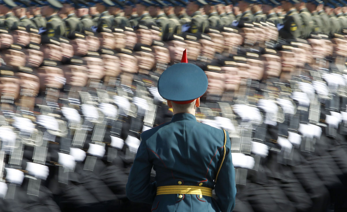 A Russian soldier stands at attention as troops march past during a rehearsal for the Victory Day parade at Moscow’s Red Square May 6, 2012.