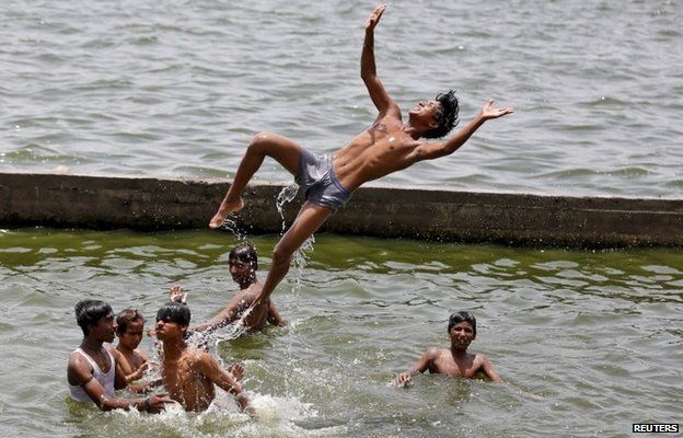 Young men jump into a river to escape the heat in Gujarat.