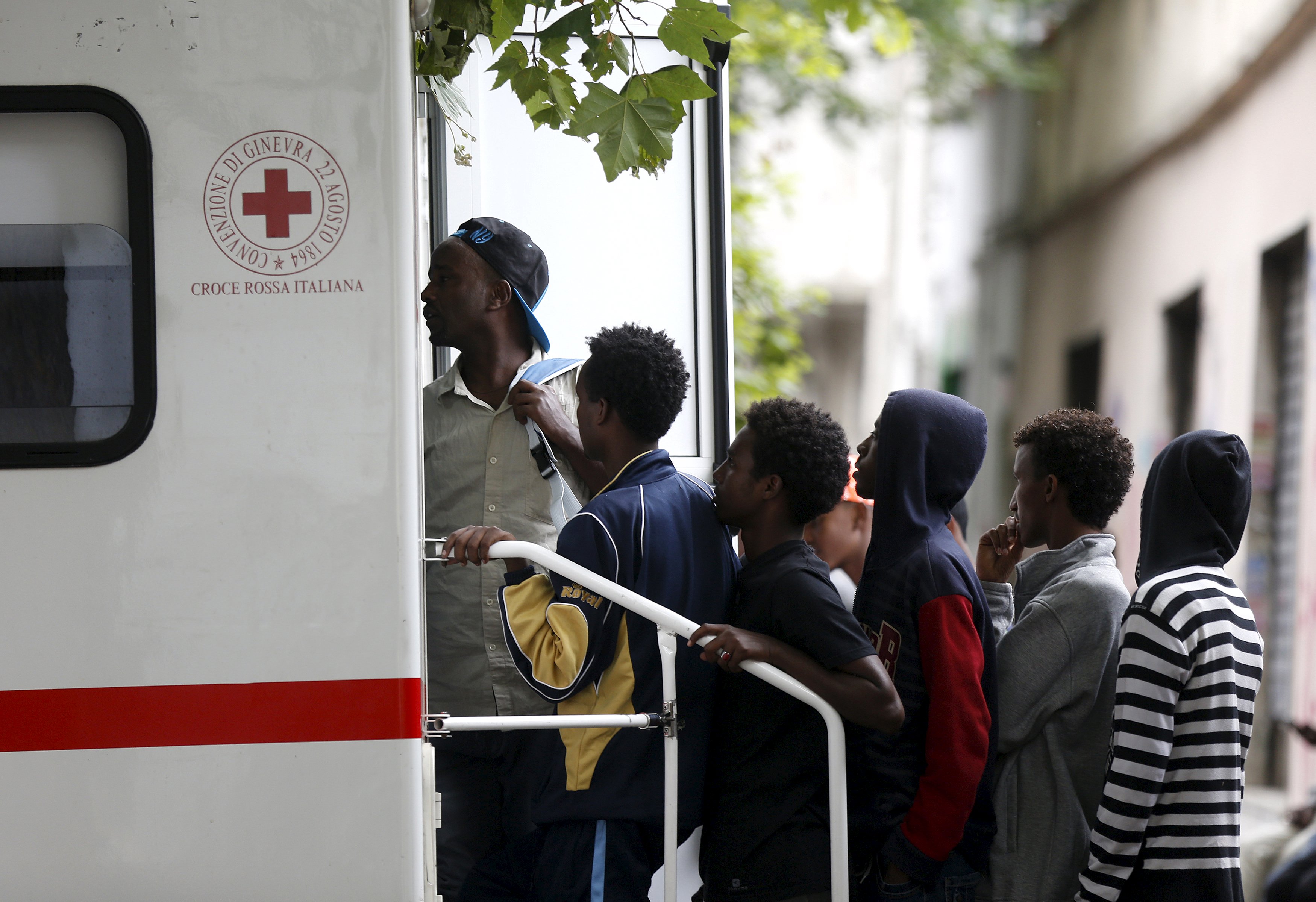 Migrants await a visit by Red Cross in front of the migration centre next to the Tiburtina station in Rome, June 12, 2015.