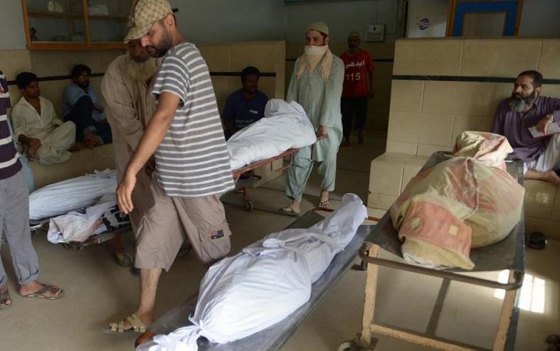 Relatives gather beside the bodies of heatstroke victims outside the cold storage of the Edhi morgue in Karachi, southern Pakistan on June 23, 2015