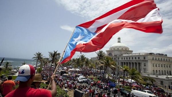 A man waves a Puerto Rico flag in San Juan May 13, 2015, as demonstrators protest austerity measures imposed because of the U.S. territory's debt crisis.