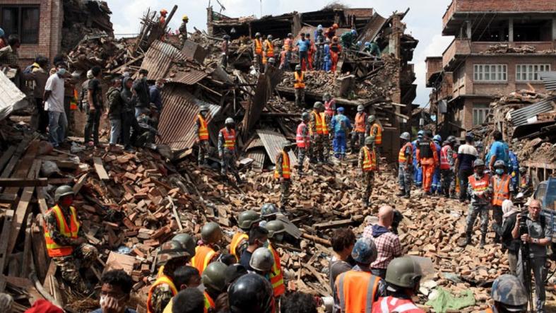 People watch as rescuers search for bodies at the site of a building which collapsed during an earthquake in Bhaktapur near of Kathmandu, Nepal on April 29, 2015.