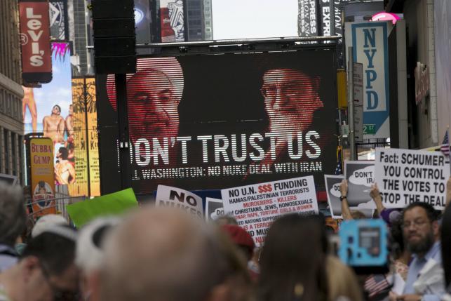 An image of Iranian leaders is projected on a giant screen in front of demonstrators during a rally apposing the nuclear deal with Iran in Times Square, New York City, July 22, 2015.