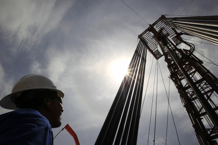 An oil worker stands near excavation pipes at a field in eastern Colombia.