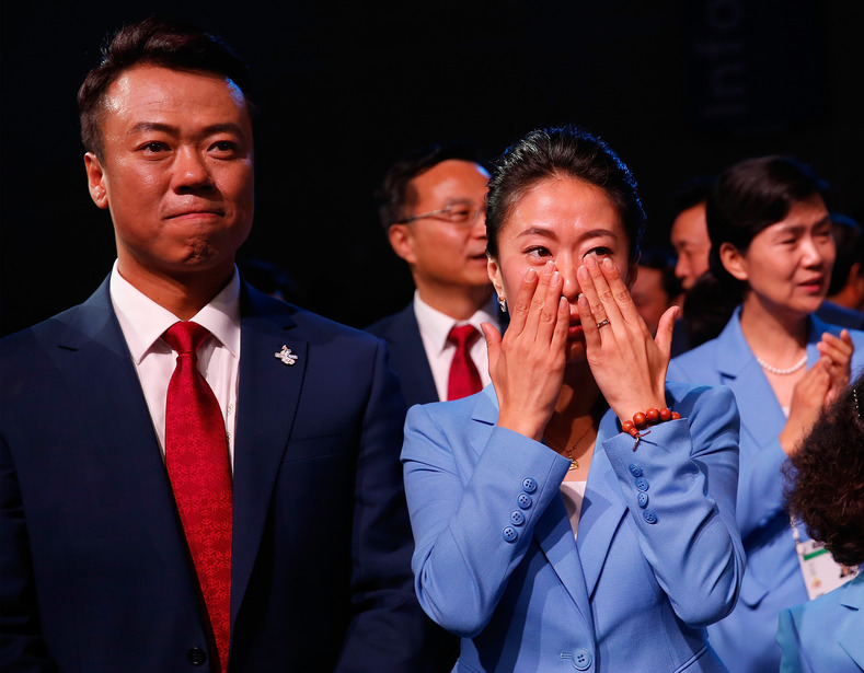 Former Winter Olympic champions Shen Xue (R) y Zhao Hongbo react after it was revealed that China will host the 2022 Winter Olympics, July 31, 2015.