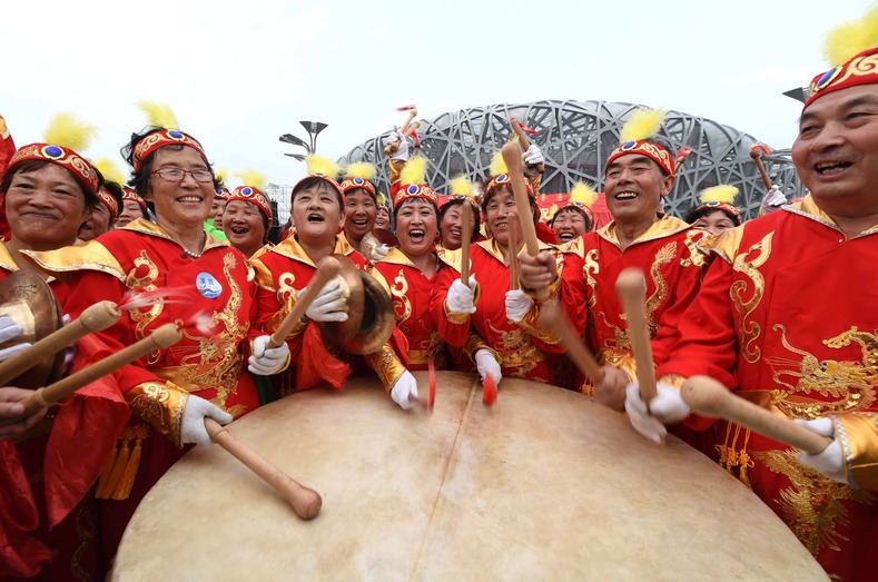 People drum to celebrate China's win in the Olympic Park in Beijing, July 31, 2015.