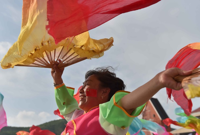 A woman dances as Chongli county residents celebrate in Zhangjiakou, Hebei province, which was chosen to co-host the games with capital Beijing, July 31, 2015.