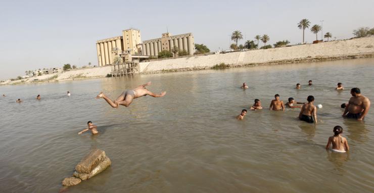 Residents dive into the Tigris river in Iraq to take a swim and cool off.