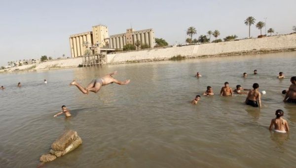 Residents dive into the Tigris river in Iraq to take a swim and cool off.