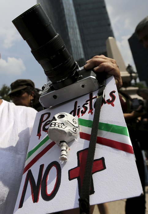 MEXICO CITY: An activist holds a camera and a placard that reads 