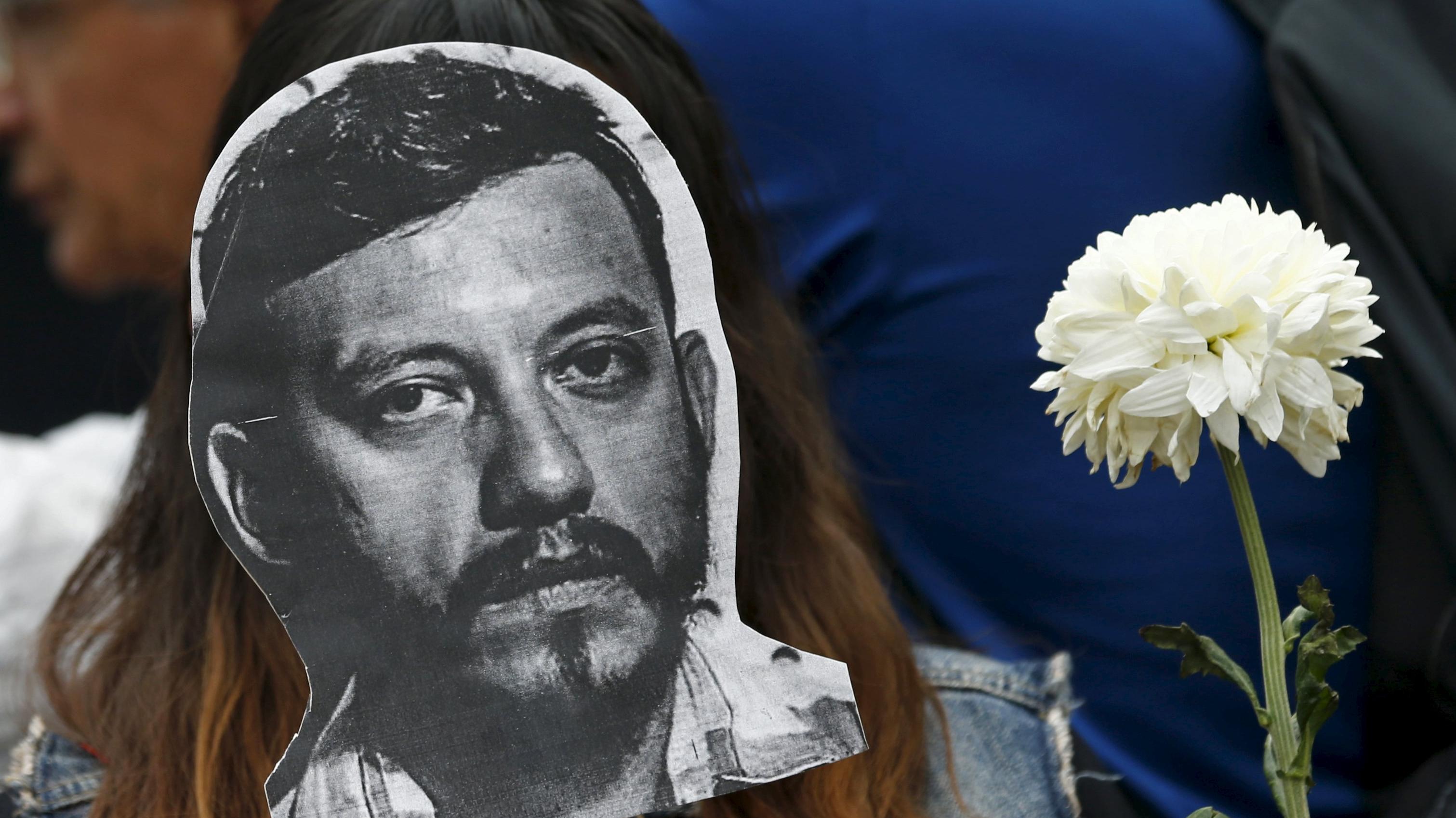 An activist holds up a picture of Ruben Espinosa at the Angel of Independence monument in Mexico City, Mexico August 2, 2015.