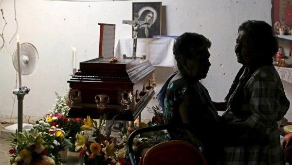 Relatives gather near the casket of Miguel Angel Jimenez during his wake in Xaltianguis in the state of Guerrero, August 9, 2015.