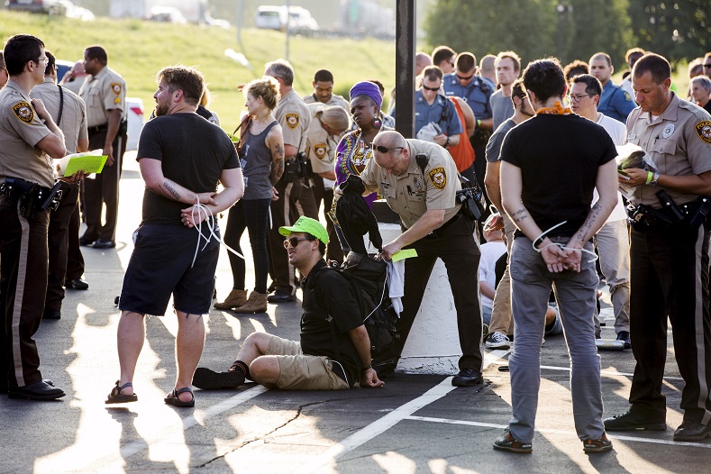 Officers from the St Louis County Police Department and the Missouri Highway Patrol process demonstrators from the 