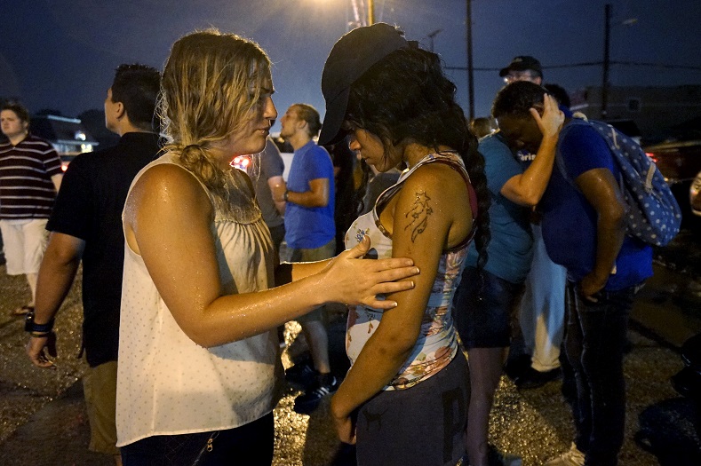 Two white women and two black women pray at the site of last year's riots on the one year anniversary of the killing of Michael Brown in Ferguson, Missouri August 9, 2015