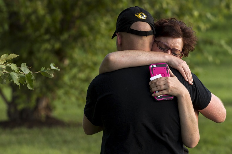 A woman cries on the shoulder of a friend after being detained and released after having a seizure while protesting with other demonstrators from the 