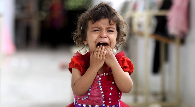 A girl cries as she walks onto the veranda at the yard of a school sheltering people displaced by Saudi-led air strikes on Yemen's northwestern province of Saada, in the capital Sanaa August 27, 2015.