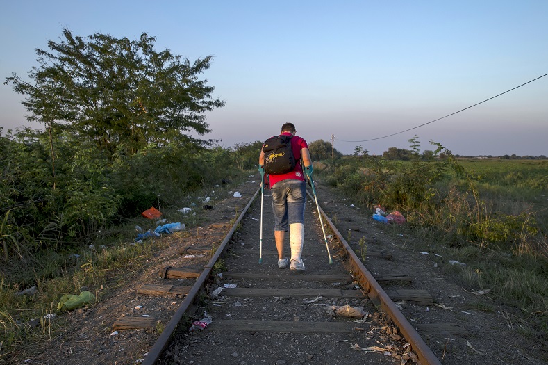 A refugee, hoping to cross into Hungary, walks along a railway track near the village of Horgos in Serbia, towards the border it shares with Hungary, September 1, 2015.