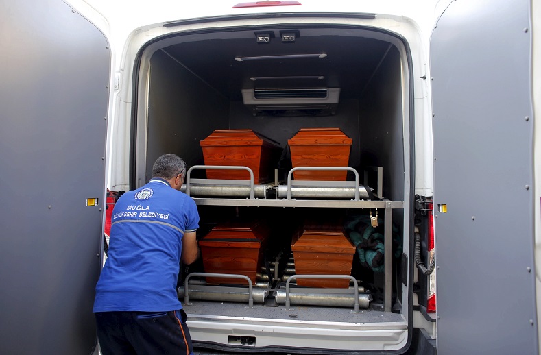 A morgue employee places coffins containing the bodies of drowned Syrian refugees into a vehicle to transport them to the airport in Mugla, Turkey, September 3, 2015.