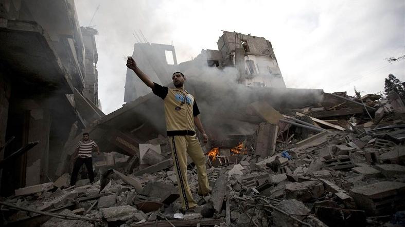 A Palestinian man stands amid debris following an Israeli air strike in Gaza City.