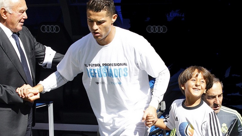 Real Madrid star striker Cristiano Ronaldo prepares to walk onto the pitch with his honored guest, Zaid Mohsen, the boy tripped by a Hungarian camerawoman.