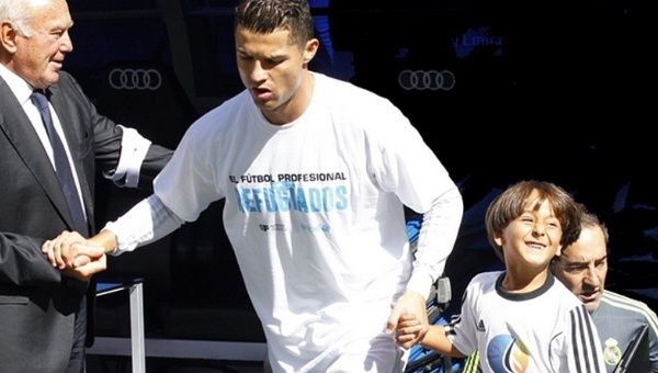 Real Madrid star striker Cristiano Ronaldo prepares to walk onto the pitch with his honored guest, Zaid Mohsen, the boy tripped by a Hungarian camerawoman.