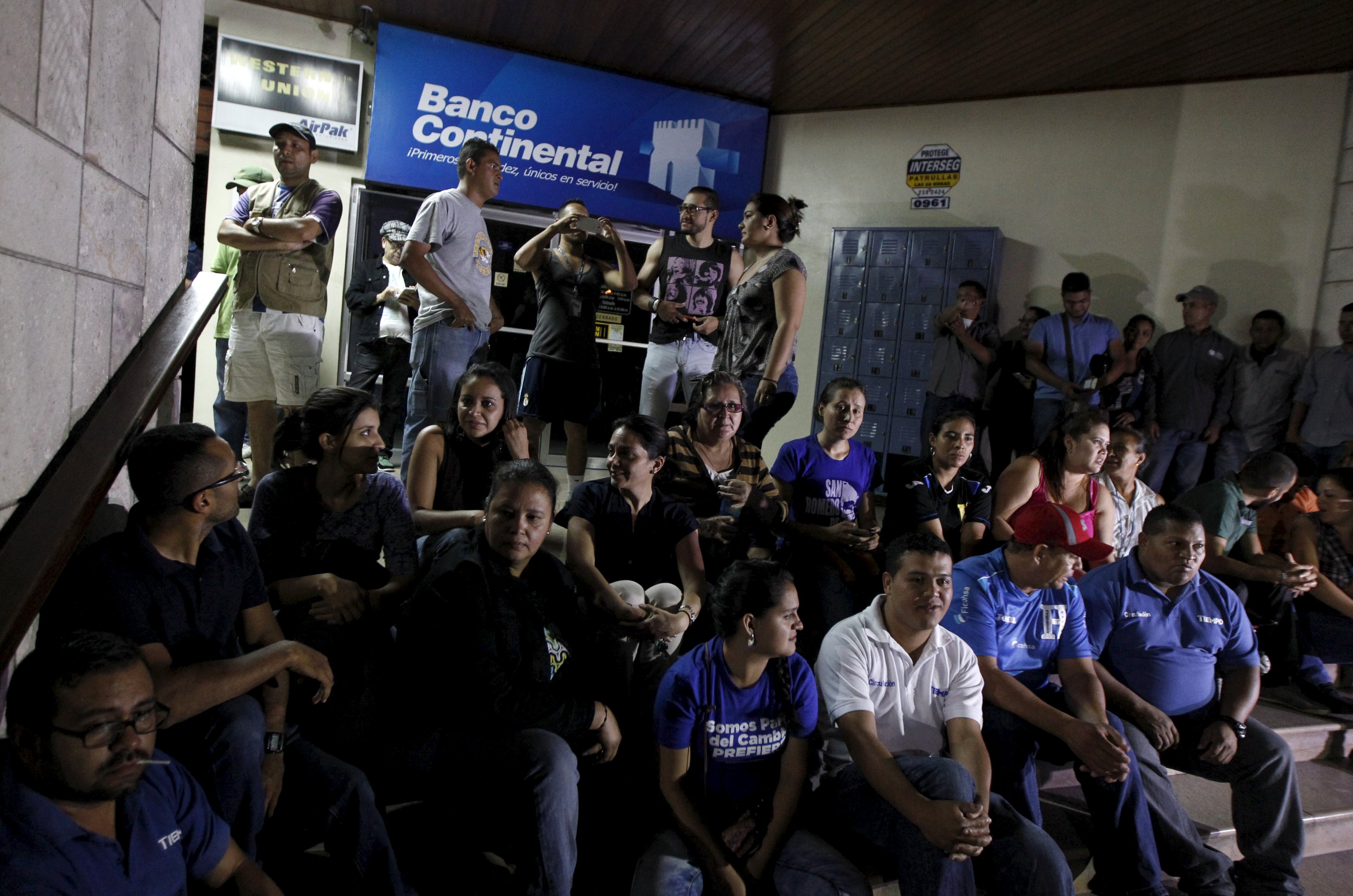 Banco Continental employees gather outside a branch of the bank in Tegucigalpa after the government ordered its liquidation, Oct. 11, 2015.