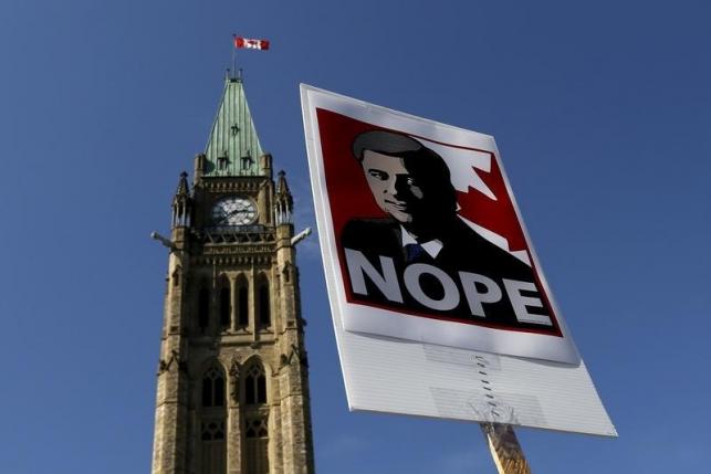 A sign featuring an illustration of Conservative leader and Canada's Prime Minister Stephen Harper is pictured during a singalong performance of 'Harperman,' a protest song against Harper, on Parliament Hill in Ottawa, Ontario September 17, 2015.