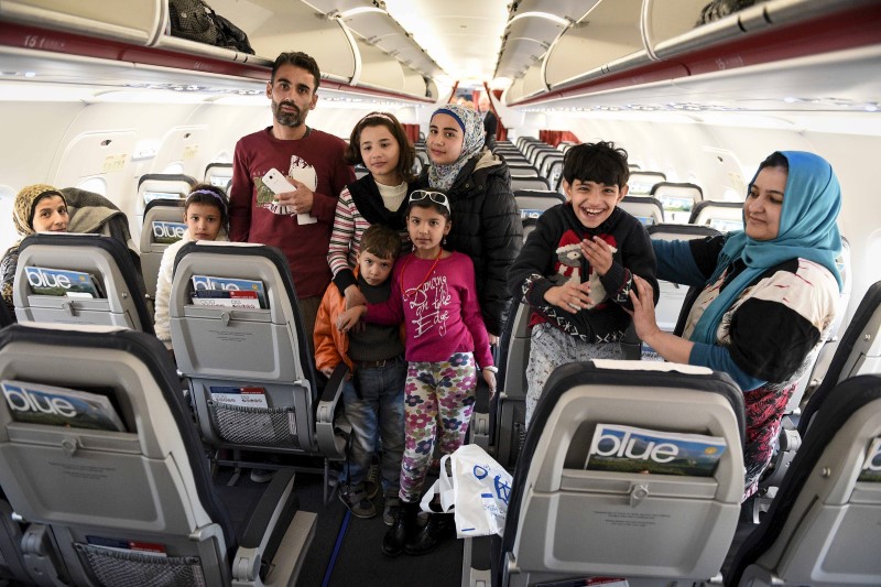 Syrian and Iraqi refugees are seen inside an airplane during their relocation process.