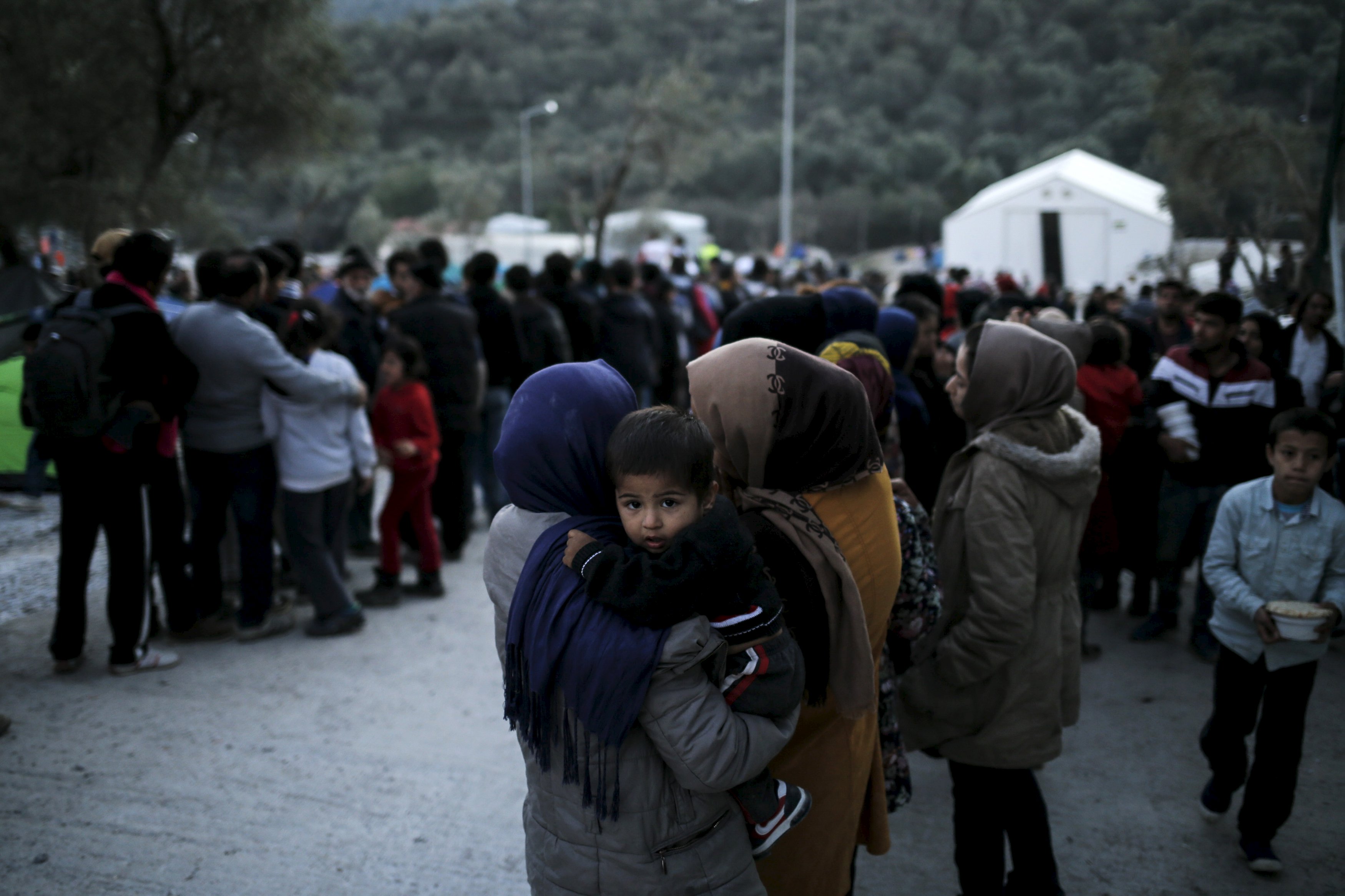 Refugees and migrants line up for a food distribution at the Moria refugee camp on the Greek island of Lesbos.