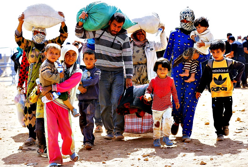 Kurdish Syrian refugees walk near the Turkish-Syrian border.