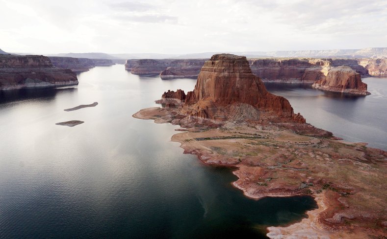 Dry land (R) that would be under water when the lake is full is seen next to Gregory Butte in Lake Powell.