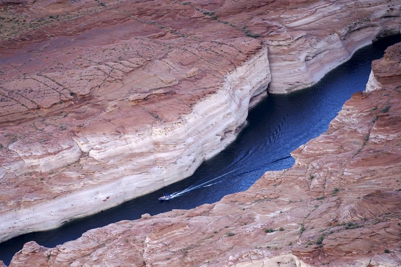 A power boat moves through a canyon at Lake Powell.