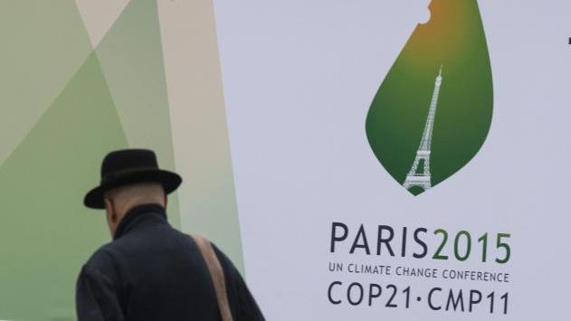 A passerby walks in front of posters for the forthcoming COP 21 World Climate Summit in Paris, France, Nov. 2, 2015.