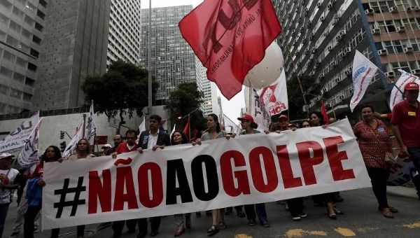 People with a banner that reads “No to the coup” attend a protest against the impeachment proceedings against President Dilma Rousseff, Brazil Dec. 8, 2015.