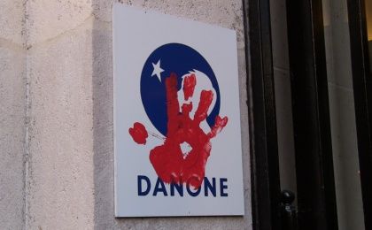 Via Campesina protesters put their red hand print on Danone's logo expressing their demand that the company stop affecting campesinos worldwide.