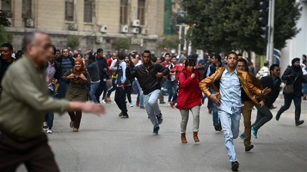 Protesters run for cover during attacks by police in Cairo, Jan. 25, 2015.