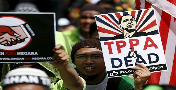 Protesters wave placards at a rally against the Trans-Pacific Partnership (TPP) in Kuala Lumpur, Malaysia, Jan. 23, 2016.