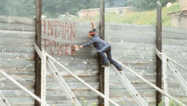 Rick St. Germaine sprays a message on the wall of the Winder Dam's spillway during a protest against granting a renewal permit for the dam, which inundated Indian lands in Lac Courte Oreilles, Wisconsin, in this 1971 handout photo.