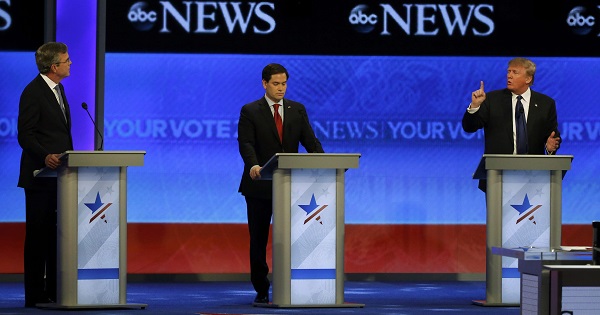 Republican U.S. presidential candidate businessman Donald Trump (R) puts his finger in front of his mouth and tells former Governor Jeb Bush (L) to 