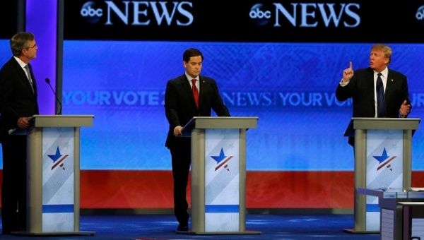 Republican U.S. presidential candidate businessman Donald Trump (R) puts his finger in front of his mouth and tells former Governor Jeb Bush (L) to 