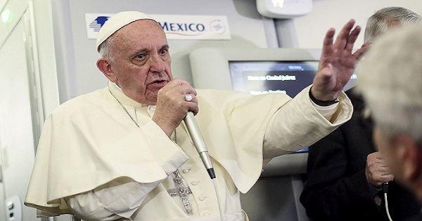 Pope Francis gestures during a meeting with the media on board the papal plane while en route to Rome.