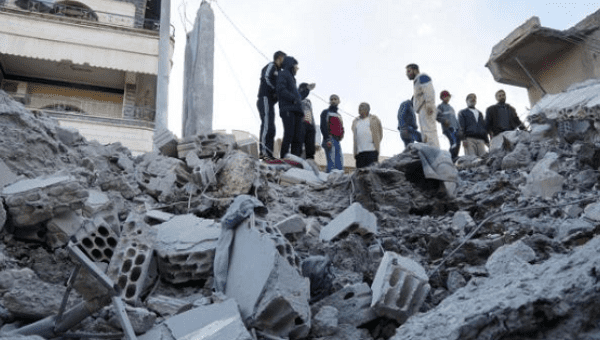 Residents inspect a damaged site from what activists said were airstrikes carried out by the Russian air force in Nawa city, Deraa, Syria, Nov. 21, 2015.