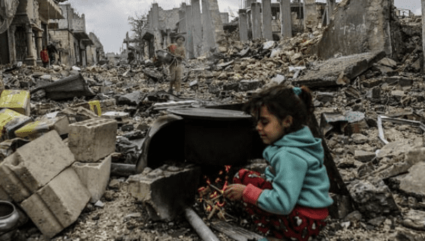 Kurdish Syrian girls are pictured among destroyed buildings in the Syrian Kurdish town of Kobane.