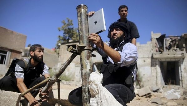 A member of the Free Syrian Army, uses an iPad during preparations to fire a homemade mortar at one of the battlefronts in Joubar, Syria, on Sept. 15, 2013. 